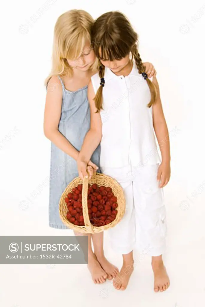 Two girls with a basket of raspberries