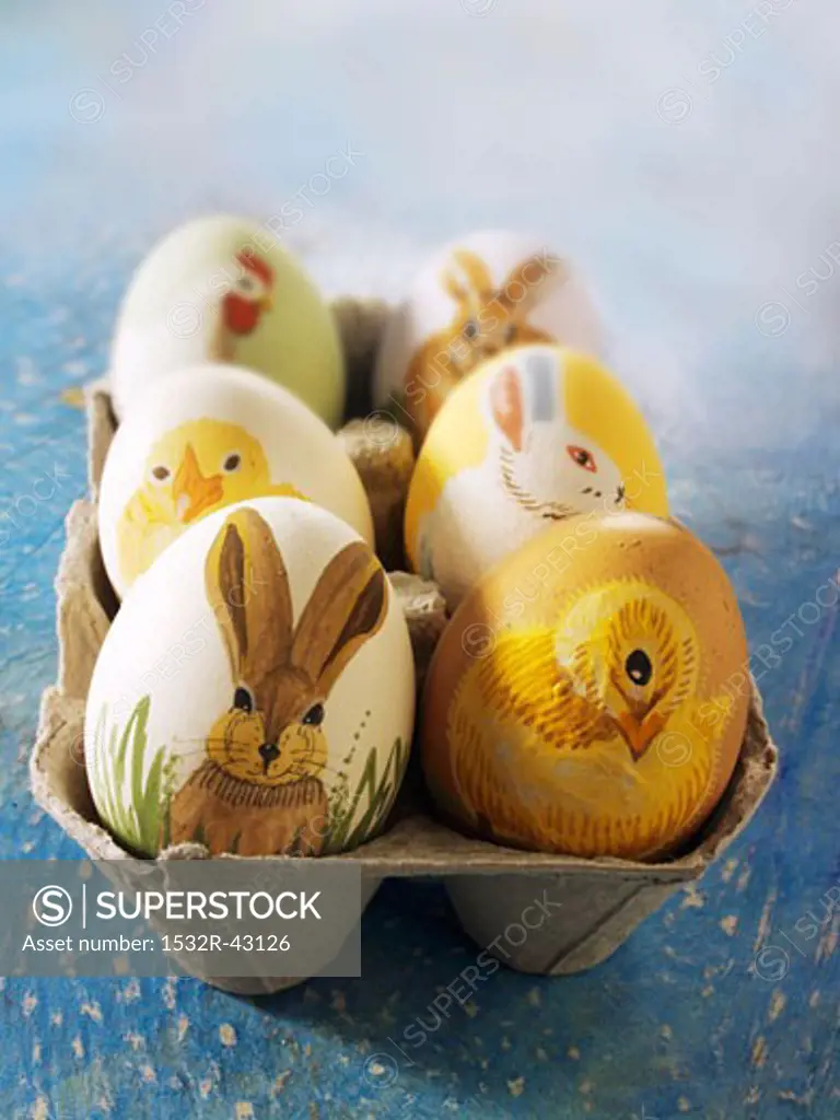 Easter eggs painted with animal motifs in an egg box