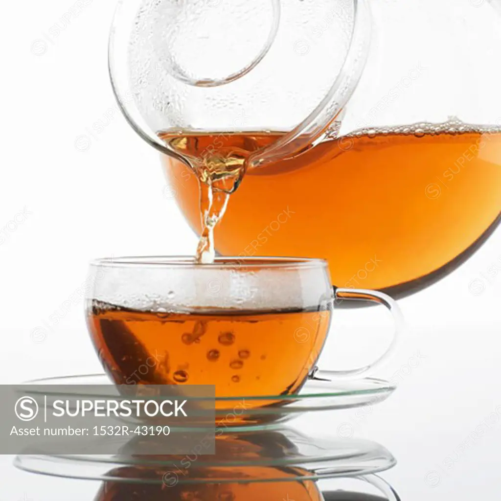 Pouring tea into a glass cup