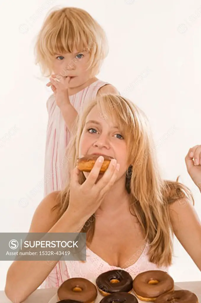 Two girls eating doughnuts