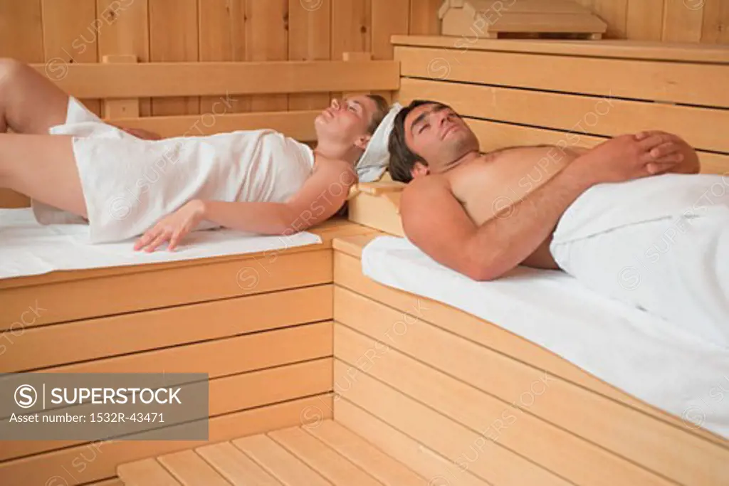 Woman and man lying in a sauna