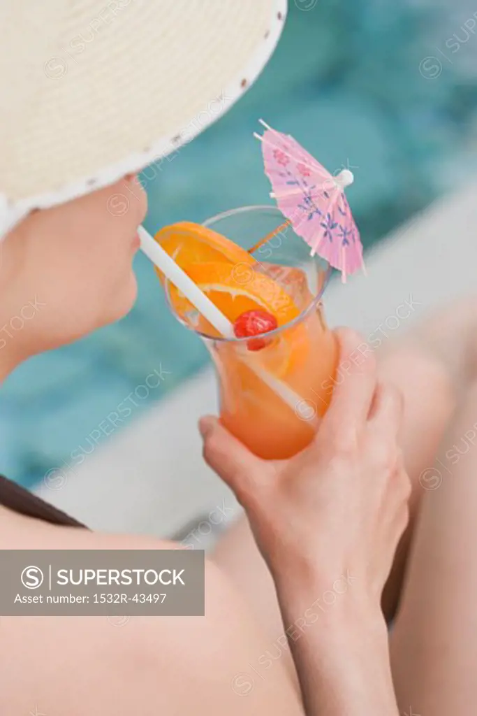 Woman drinking Planter's Punch by pool