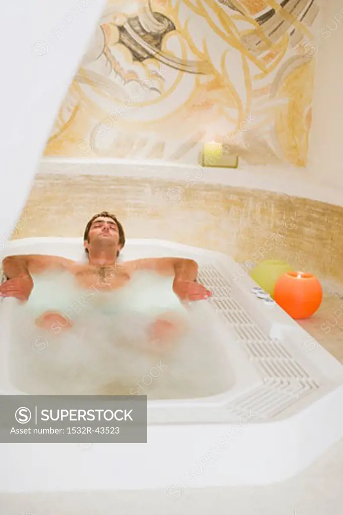 Young man lying in jacuzzi
