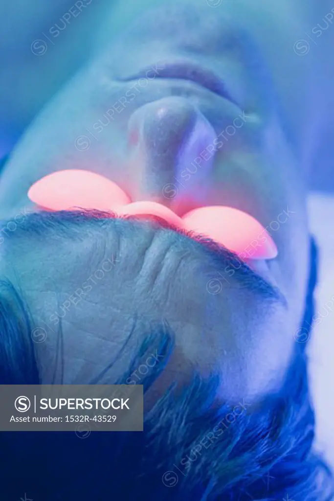 Young man in tanning goggles on tanning bed (close-up)