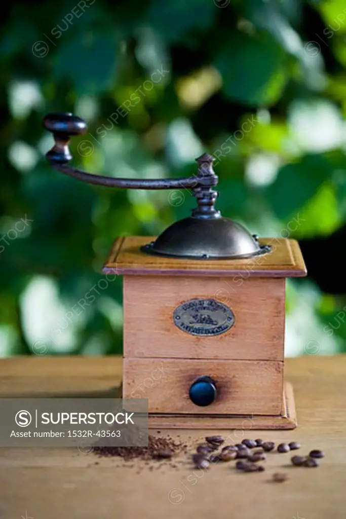 A coffee mill with coffee beans and ground coffee