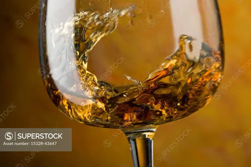 Swirling cognac in glass (close-up)