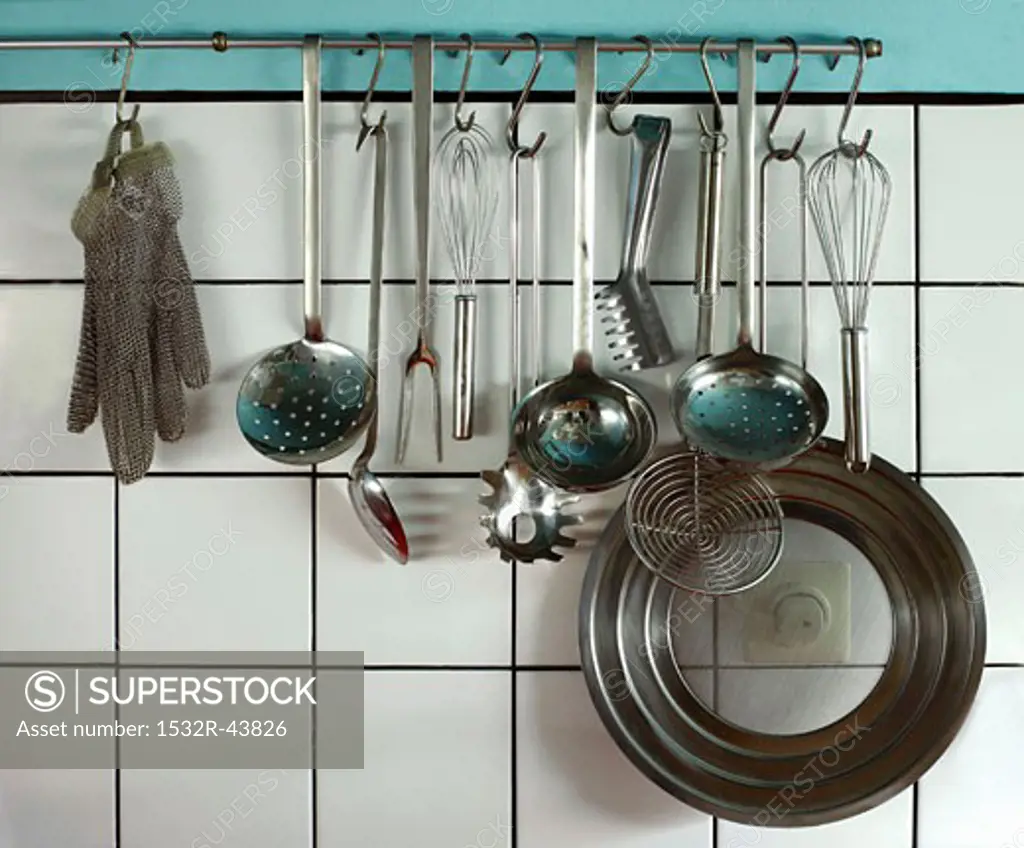 Various kitchen utensils hanging on a bar