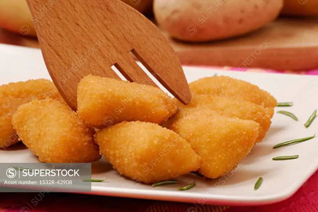 Potato croquettes with wooden fork (close-up)
