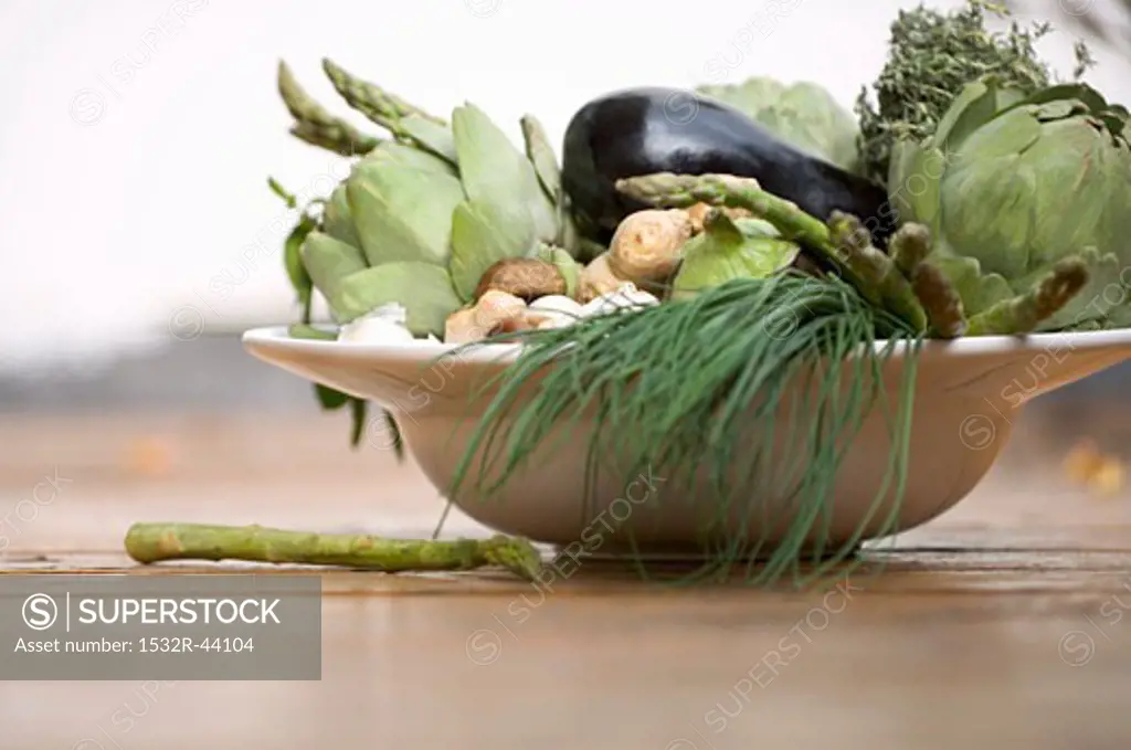 Bowl of vegetables: artichokes, aubergines, chives etc.