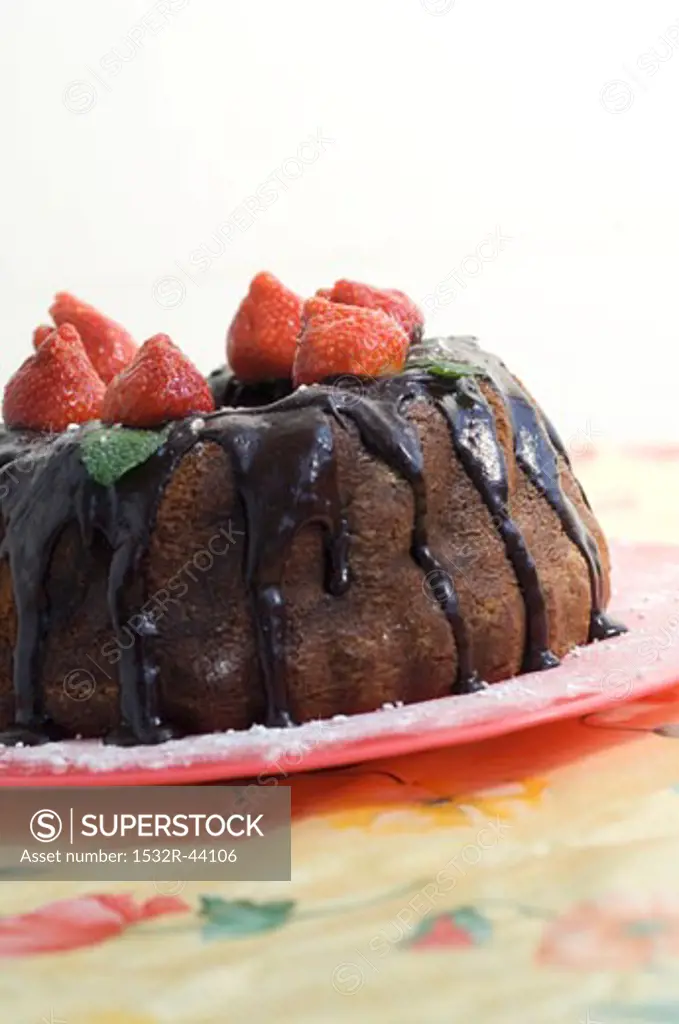 Gugelhupf with chocolate sauce and fresh strawberries
