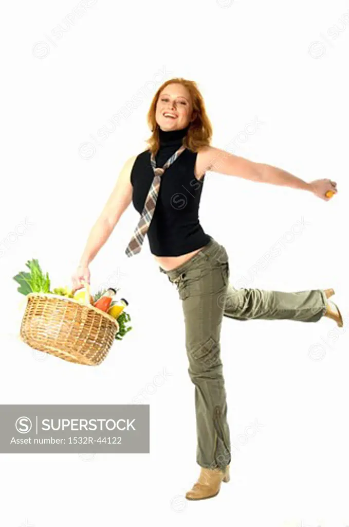 Young woman holding shopping basket full of fresh food