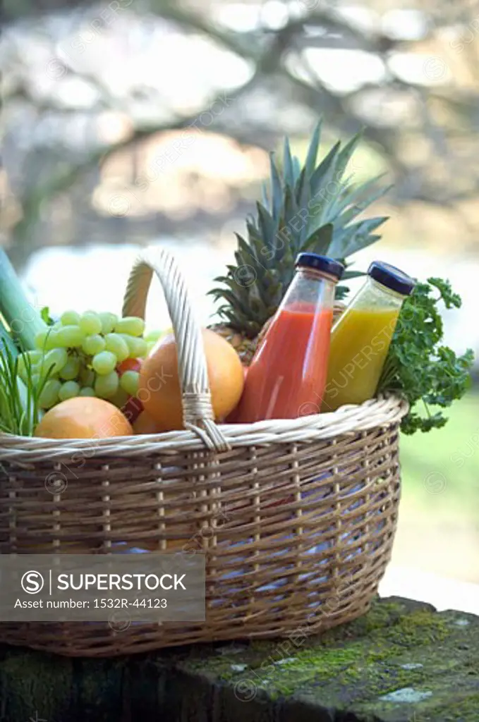 Fresh fruit, vegetables and juice in shopping basket