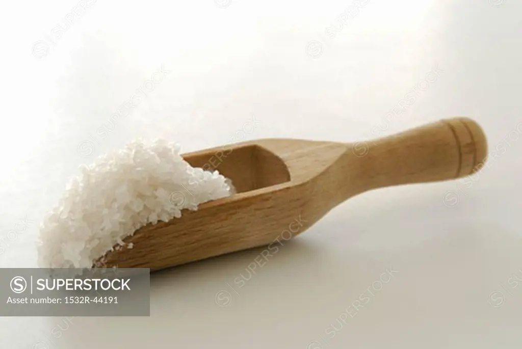 Coarse sea salt in a wooden scoop