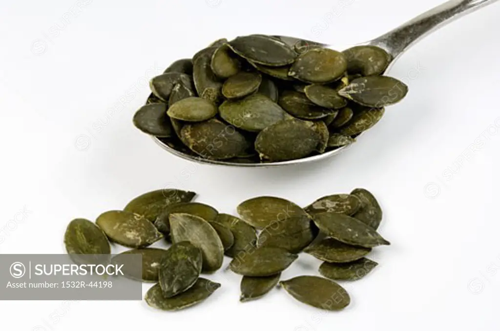 Pumpkin seeds on and beside a spoon