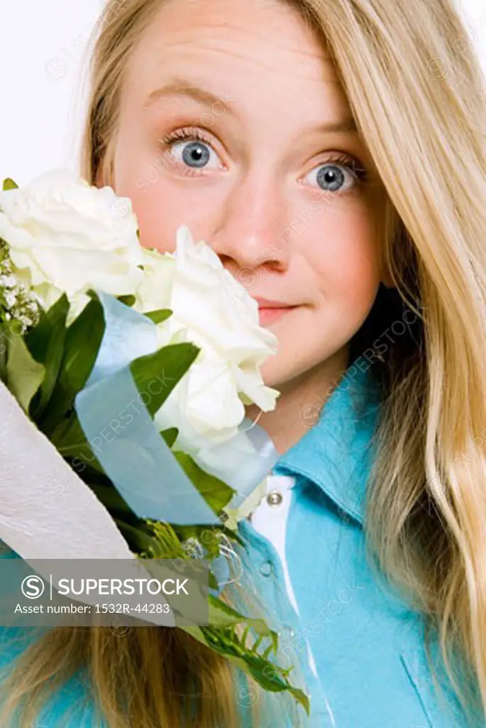 Young girl smelling bouquet of white roses
