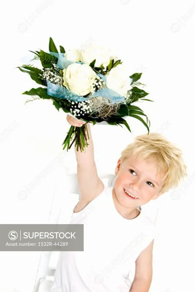 Blond boy holding bouquet of white roses