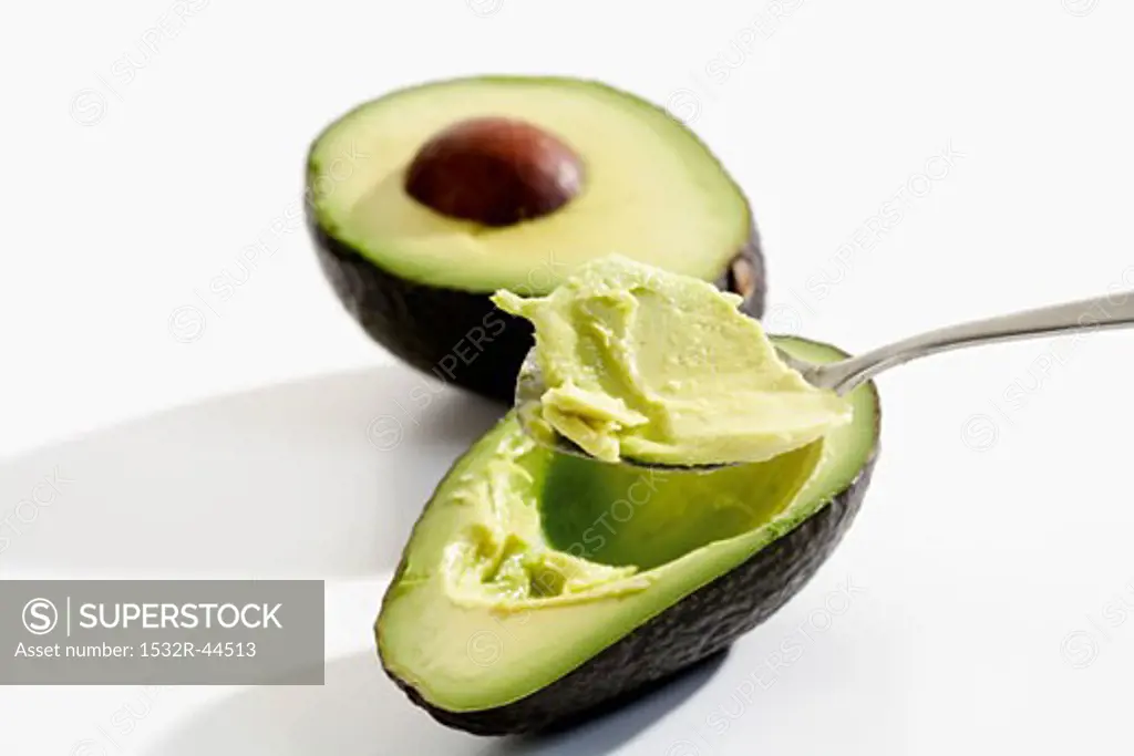 Hollowing out an avocado with a spoon