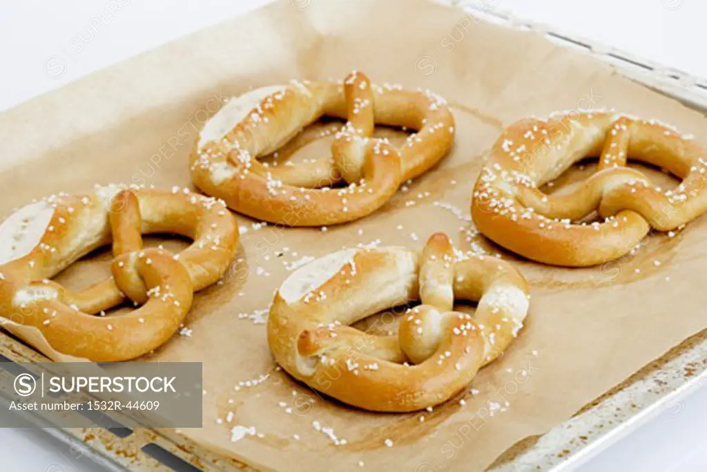 Four pretzels on a baking tray