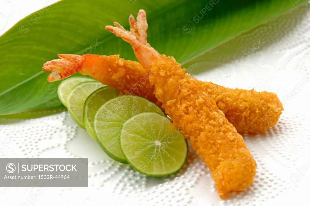 Breaded, deep-fried prawns with slices of lime