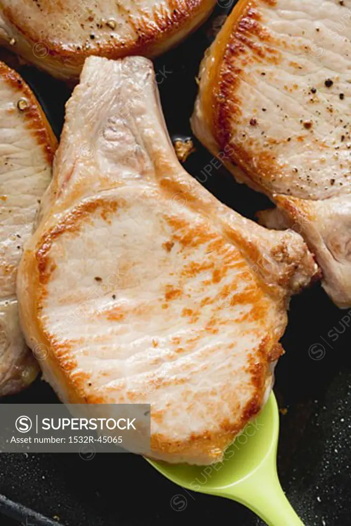 Fried pork chops in frying pan