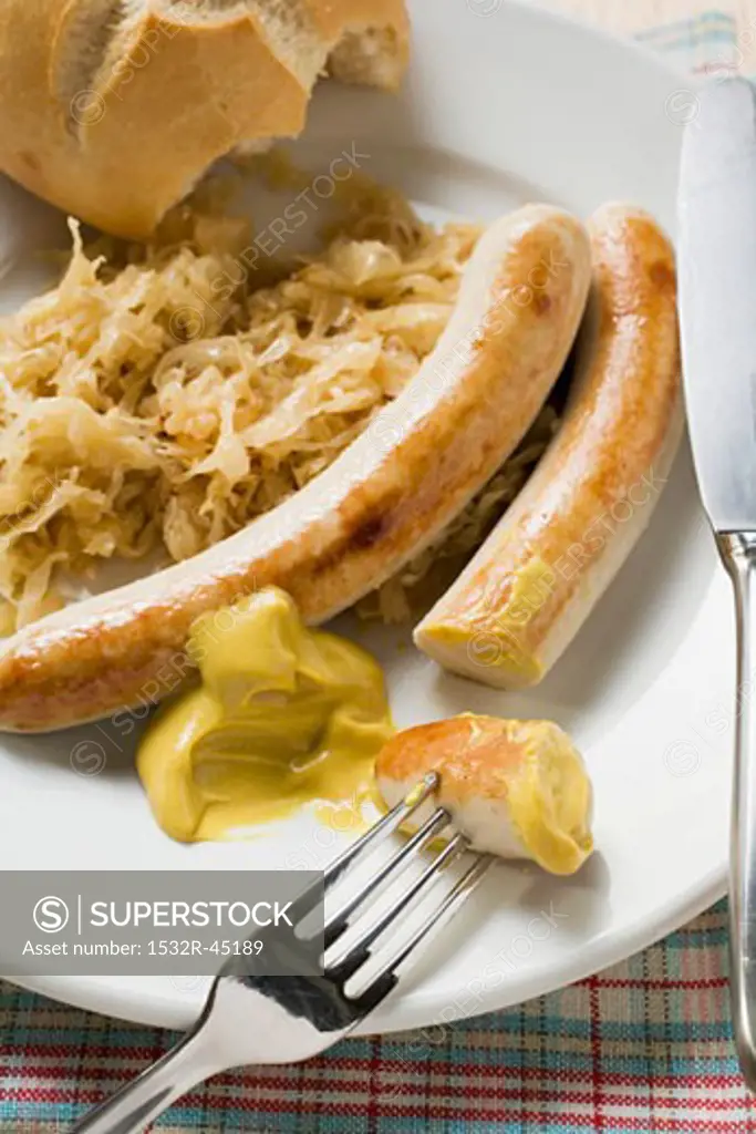 Sausages with sauerkraut, mustard & bread roll (bites taken)