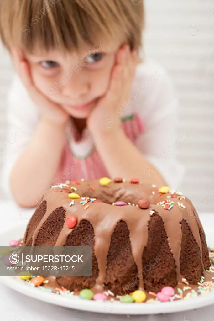 Small boy looking at ring cake with coloured chocolate beans