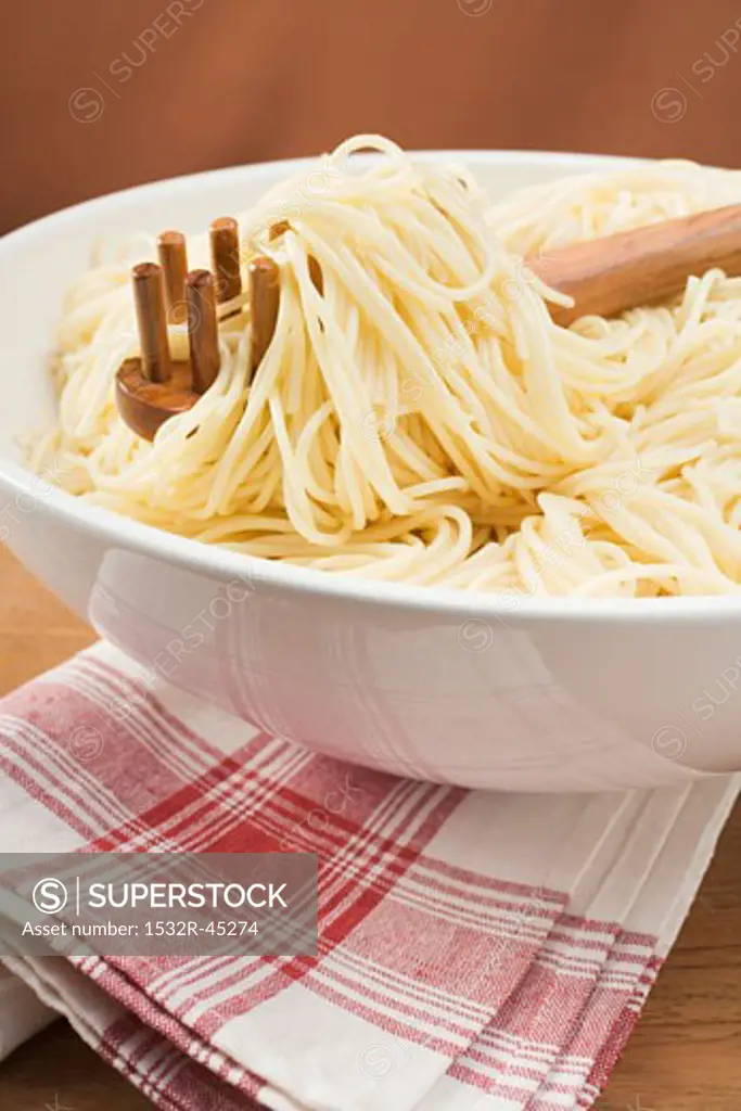 Spaghetti with spaghetti server in large bowl