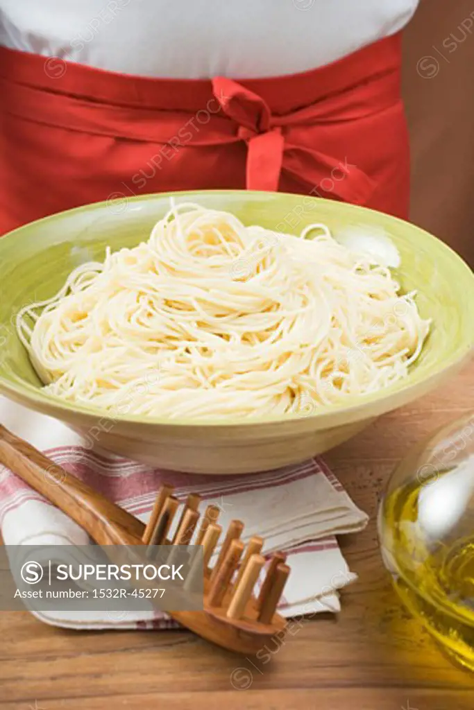 Cooked spaghetti in bowl, spaghetti server beside it
