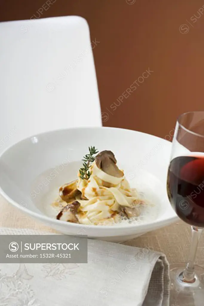 Ribbon pasta with ceps and cream sauce, glass of red wine