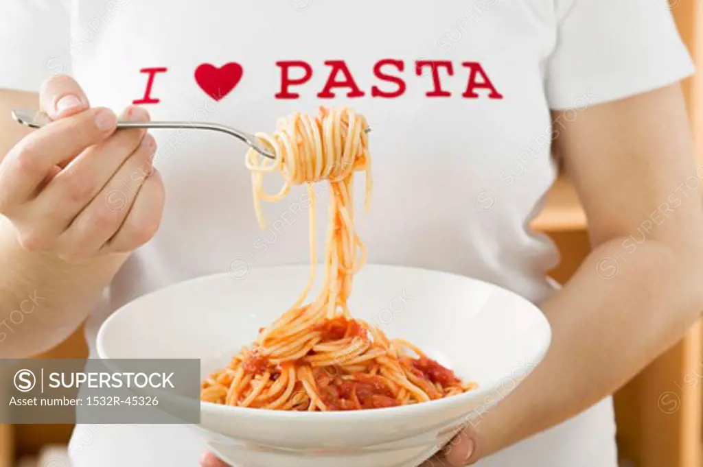 Woman eating spaghetti with tomato sauce