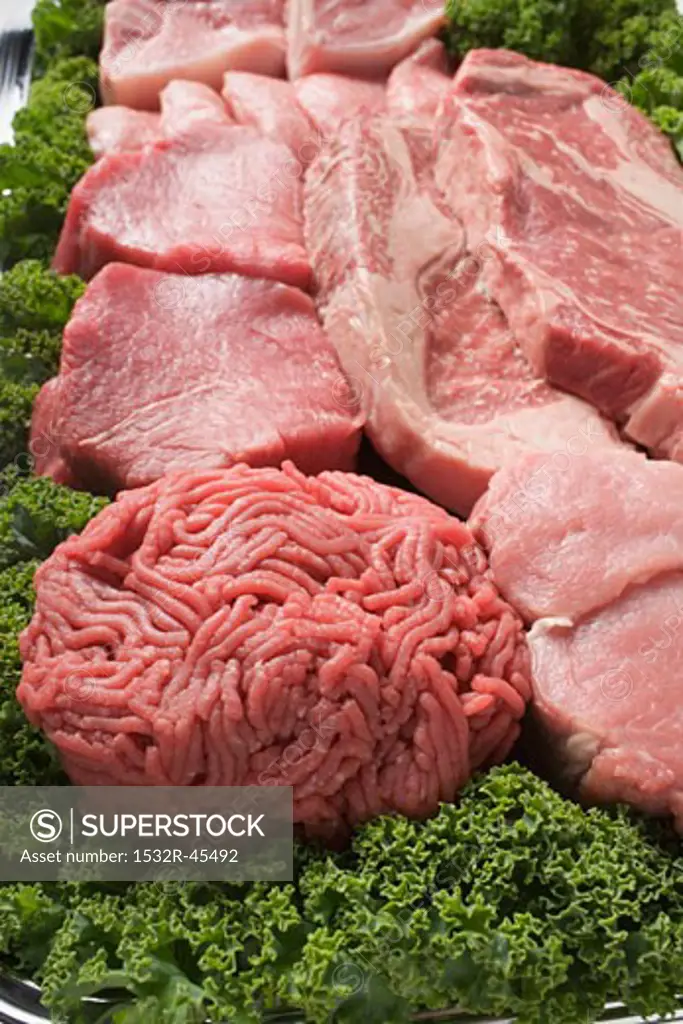 Various types of meat surrounded by parsley