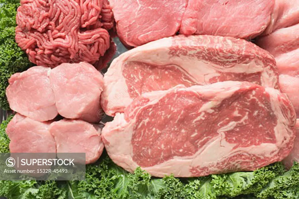 Various types of meat surrounded by parsley