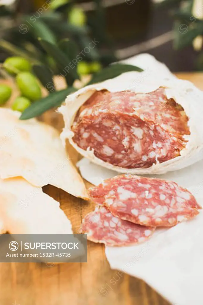 Salami and crackers on wooden table