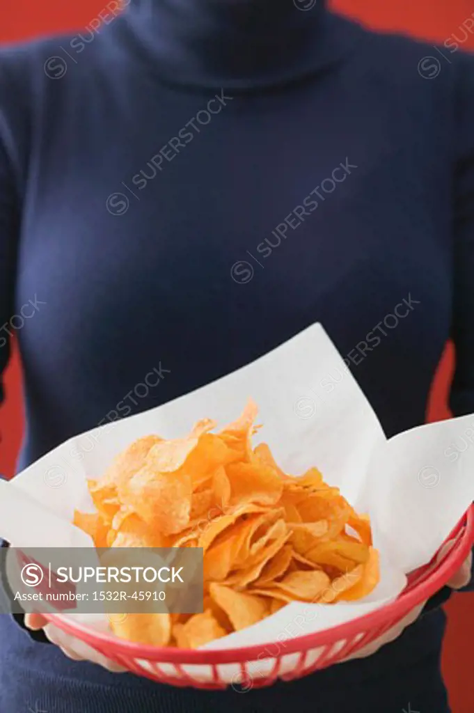 Woman holding basket of crisps