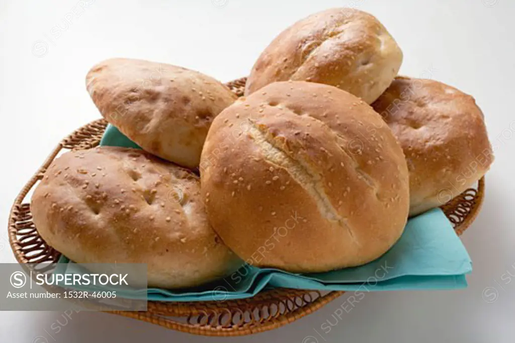Several sesame buns in bread basket