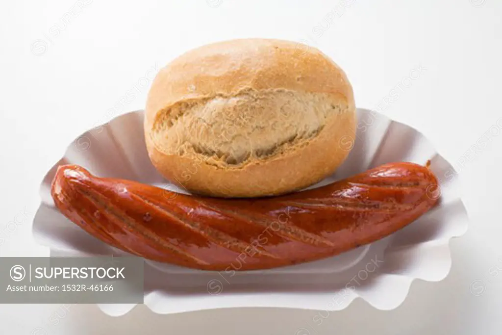 Sausage (bratwurst) and baguette roll in paper dish