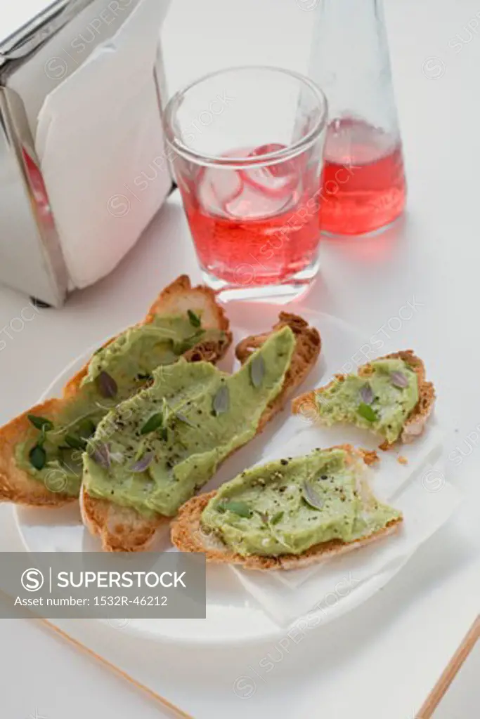 Bruschetta with avocado spread on plate, Campari Soda