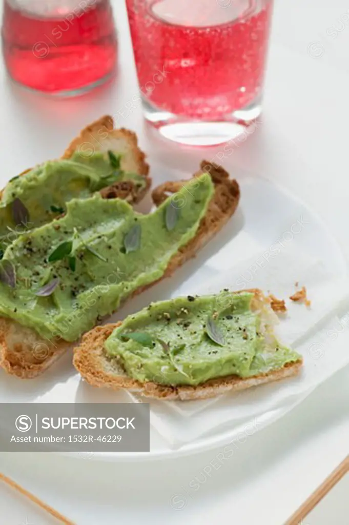 Bruschetta with avocado spread on plate, Campari Soda