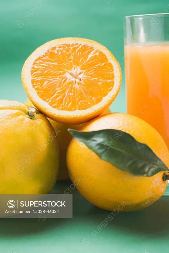 Glass of orange juice and several oranges (detail)