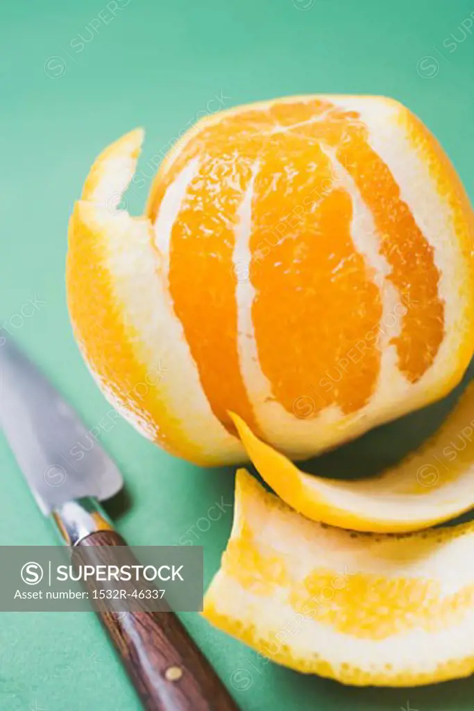 Peeled orange, knife beside it