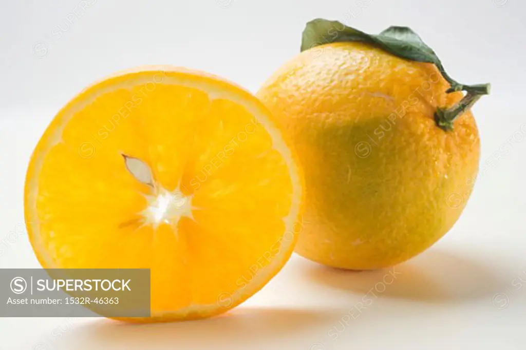 Slice of orange in front of whole orange