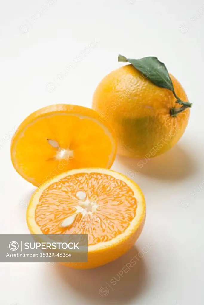 Slice of orange, whole orange with leaf and orange half
