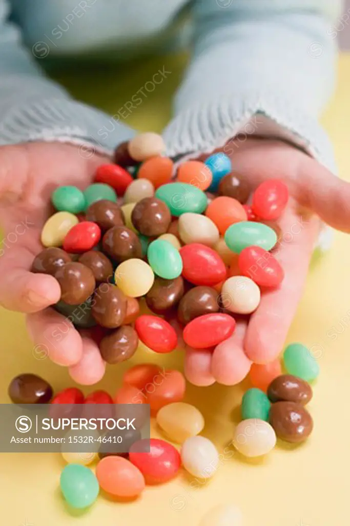 Child's hands holding coloured sugar eggs
