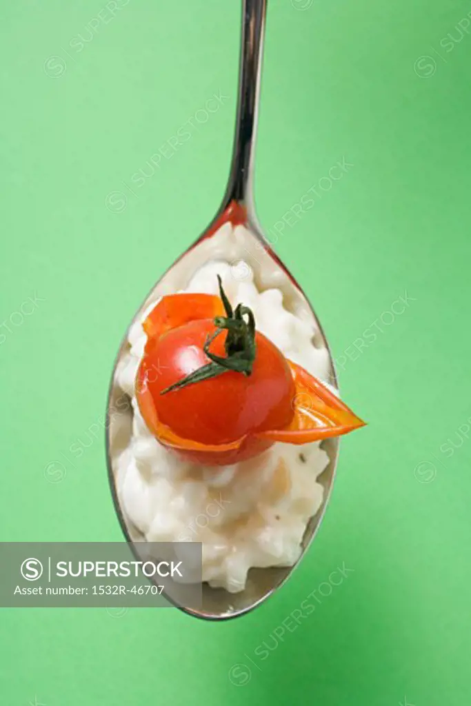 A spoonful of risotto with cherry tomato (overhead view)