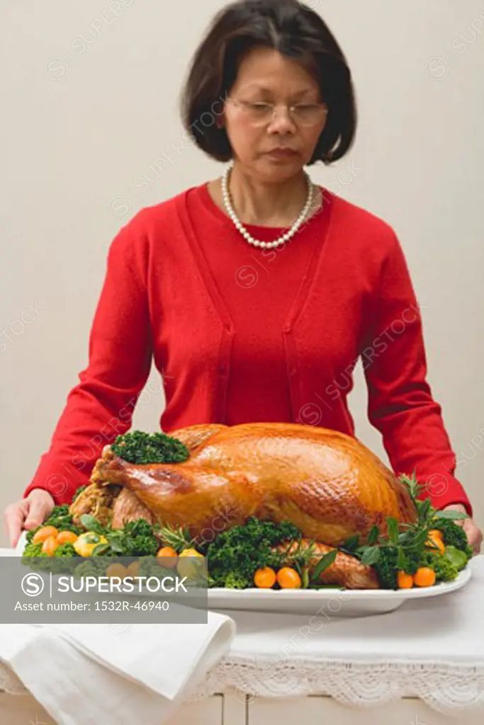 Woman holding roast turkey on large platter