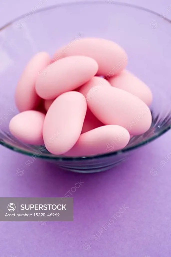 Pink sugared almonds in glass dish