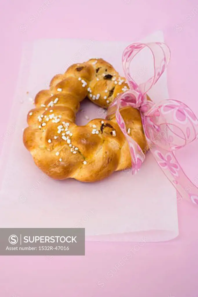 Plaited bread ring with pearl sugar and pink bow