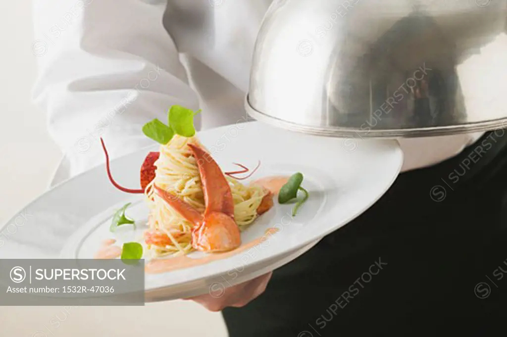 Waiter serving linguine with lobster
