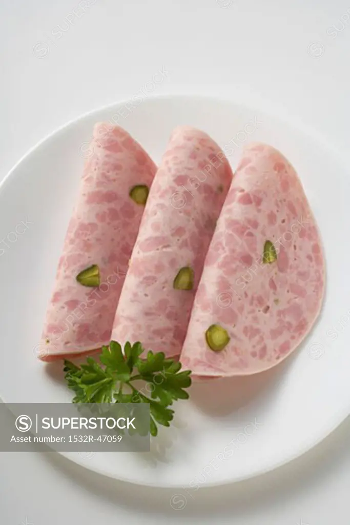 Three slices of Bierschinken (ham sausage) with parsley on plate