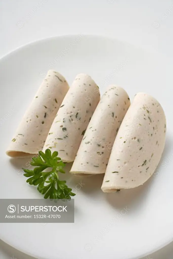 4 slices of Gelbwurst (pork & veal sausage) with parsley on plate